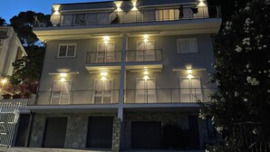 A multi-story residential building with balconies, multiple garage doors, and a paved driveway. - Villa Mary - Two Bedroom Apartment, Sleeps 4 (Marina di Andora)