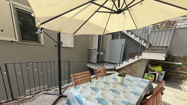A patio with a table and chairs, a pergola, and a staircase leading to an upper level. - Villa Mary - Two Bedroom Apartment, Sleeps 4 (Marina di Andora)