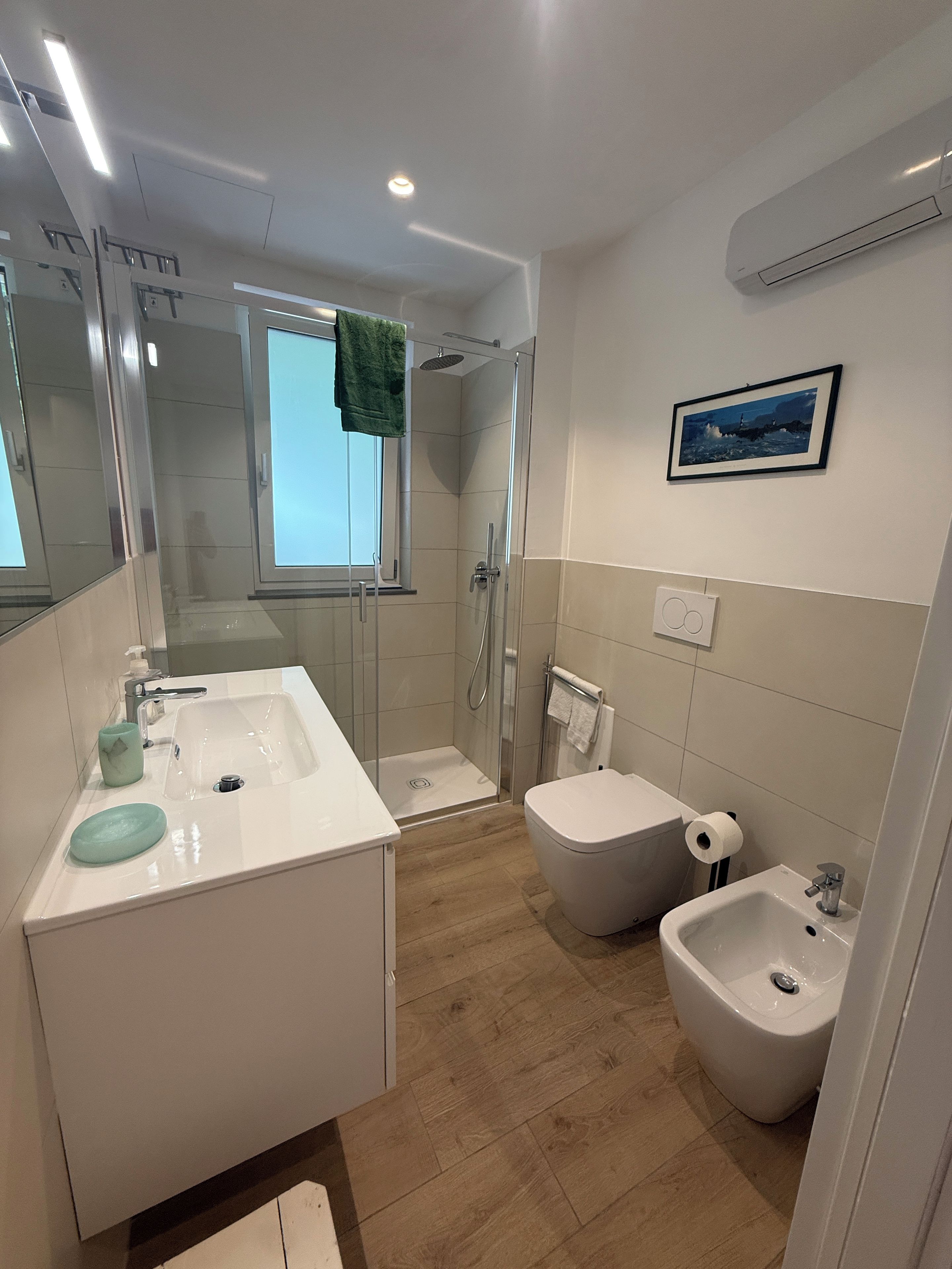 Ein modernes Badezimmer mit Dusche, Toilette, Bidet und Waschbecken.