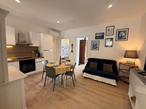 Un espacio habitable pequeño con comedor, kitchenette y sofá.