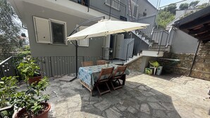 An outdoor patio with a table and chairs, surrounded by potted plants. - Villa Mary - Two Bedroom Apartment, Sleeps 4 (Marina di Andora)
