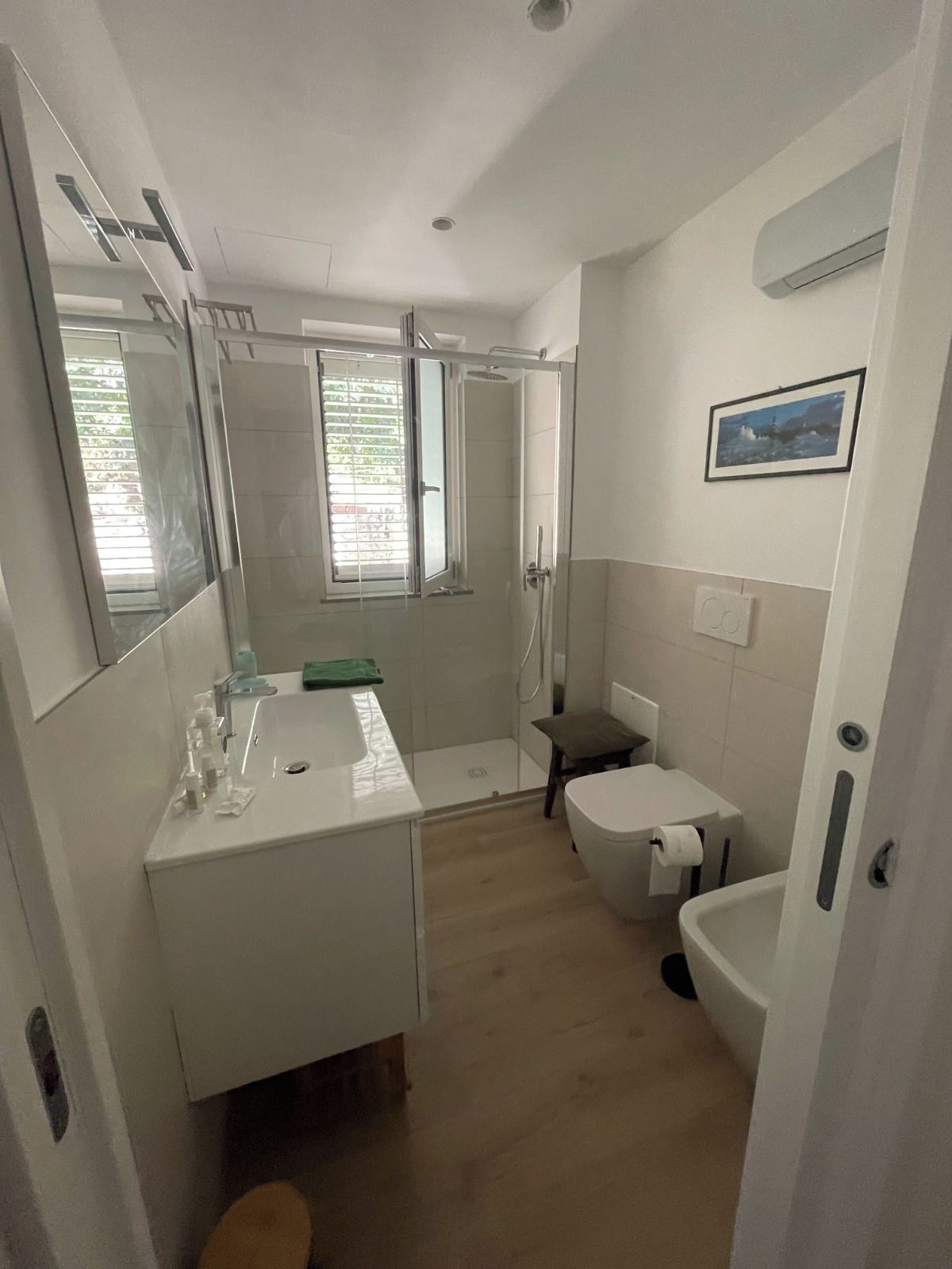 A compact bathroom with a shower, toilet, and sink.