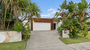 A modern house with a garage, surrounded by tropical plants. - Pottsville Paddock - Private pool, sauna, home gym, close to the beach & creek and bring the pets (Pottsville)