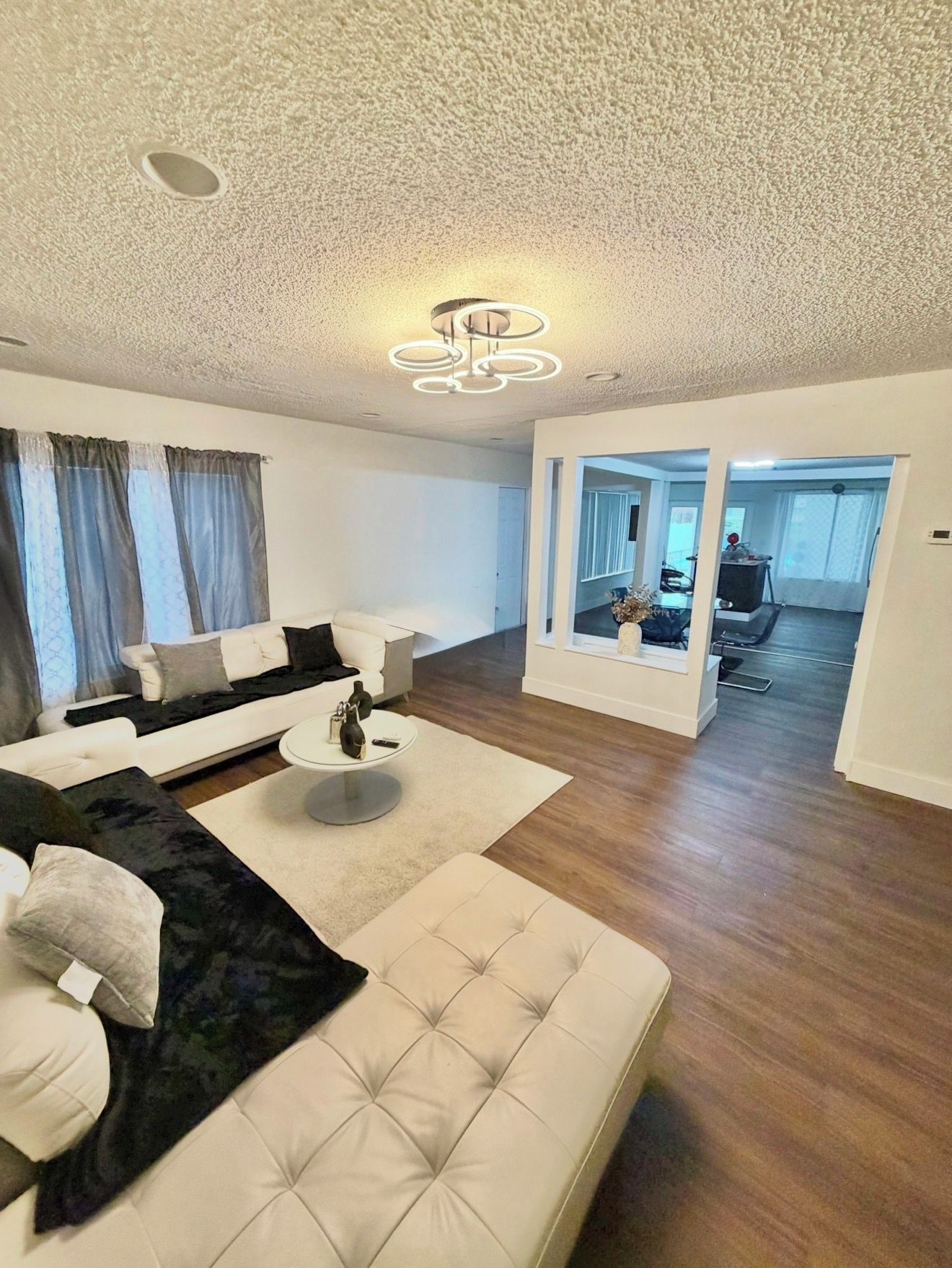 A modern living room with a sofa, a coffee table, and a large mirror.