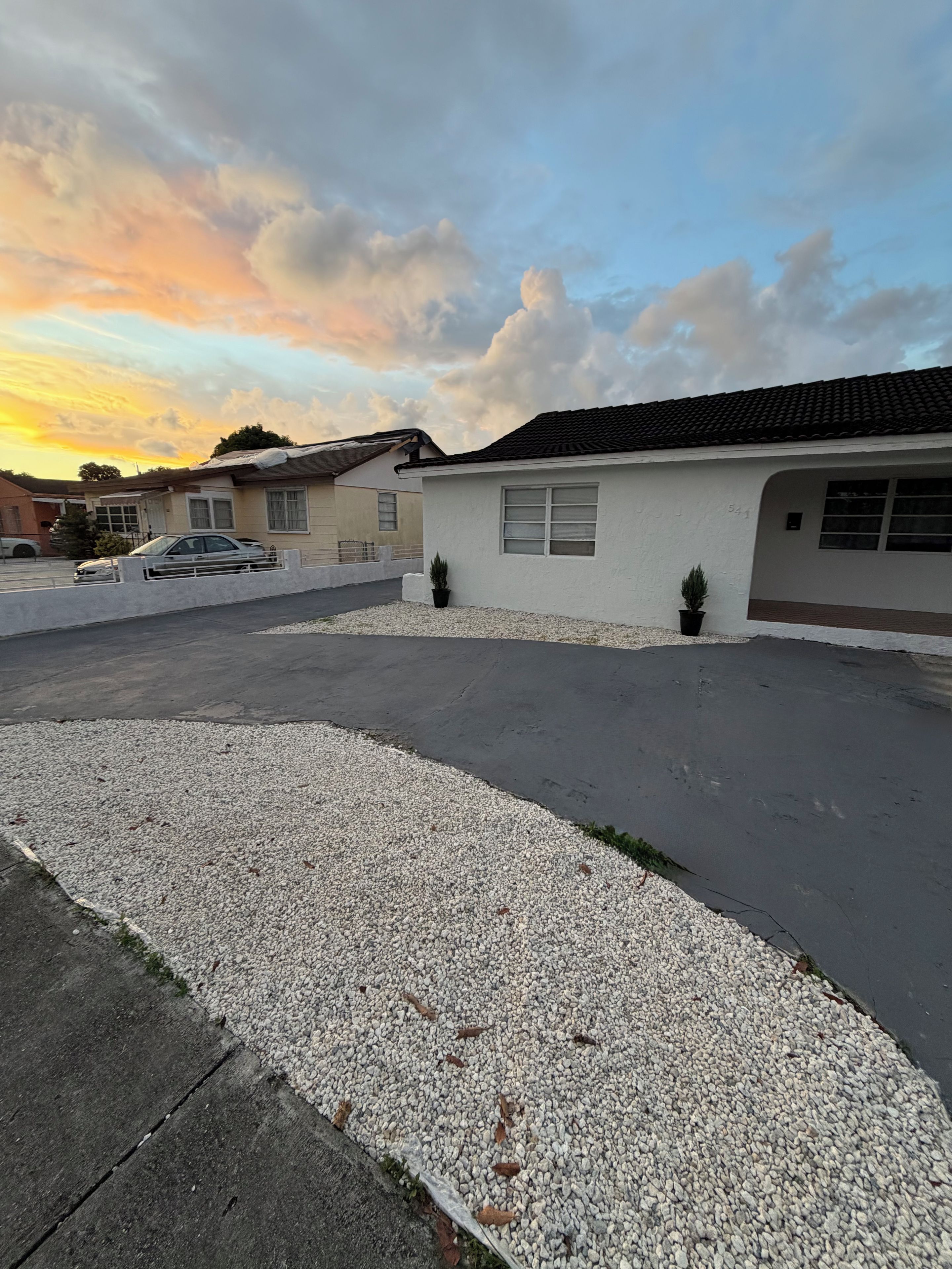 Zona residencial con casas, un camino de entrada y un sendero de grava.