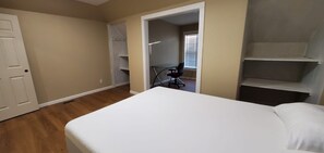 Ein Schlafzimmer mit einem Bett, einer Tür und einem Kleiderschrank.