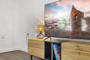 A flat-screen TV on a wooden TV stand with a cable TV box below it. - Quiet 4BR Near Lake Somerville | Boat Parking (Somerville)