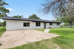 A single-story house with a flat roof, a front porch, and a driveway. - Lakebound House: Ping Pong & Starlink WiFi Near (Somerville)