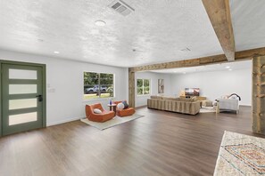 Amplia sala de estar con un conjunto de sofás, una mesa de centro y un televisor.