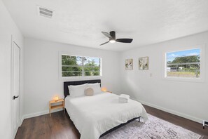 A bedroom with a bed, a ceiling fan, two bedside tables, and two windows. - Quiet 4BR Near Lake Somerville | Boat Parking (Somerville)
