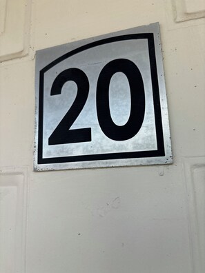 A metallic sign with the number 20 on a wall.