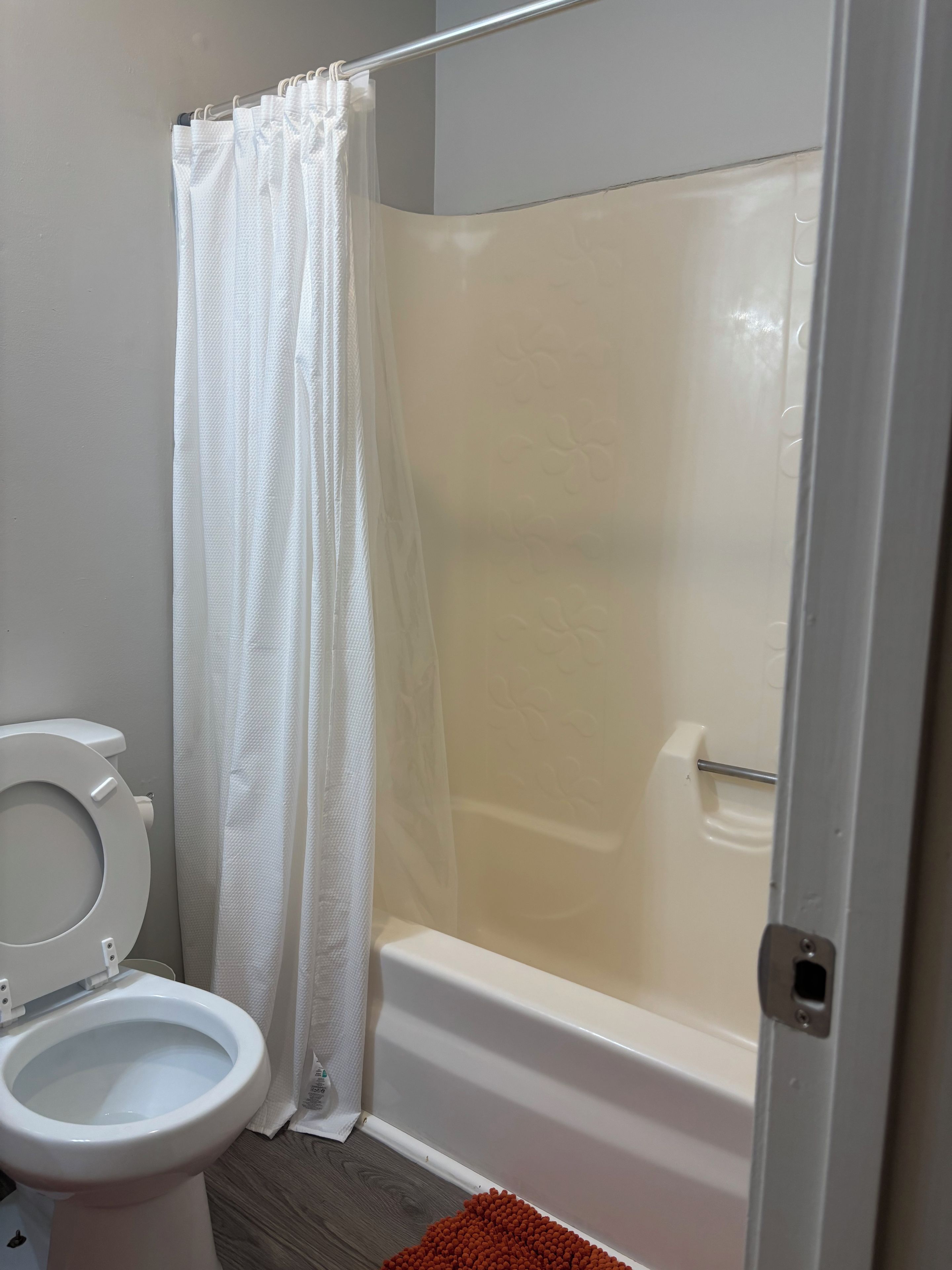 A bathroom with a toilet, a shower with a glass door, and a bathtub.