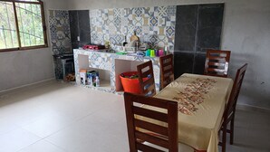 A dining area with a tiled backsplash, a kitchen counter with various items, and a window providing natural light.