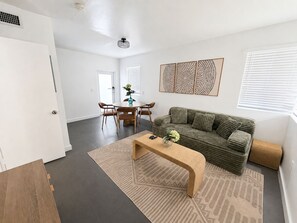 A modern living room with a sofa, coffee table, and dining area. - King Retreat with Pool near Miami Beach (Miami)