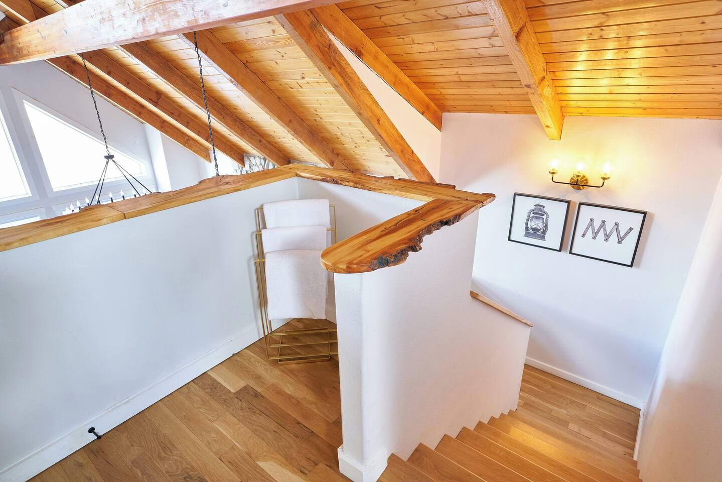A wooden staircase with a white wall and a framed picture.