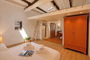 Ein Hotelzimmer mit Bett, einer Zeitschrift, einer Leiter, einem Schrank und Blick auf den Speisesaal.