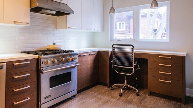 Una cocina con horno empotrado, estufa a gas y ventana con vistas al exterior.