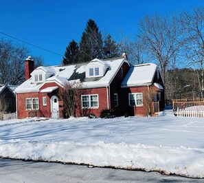 A red brick house with a snow-covered roof and a clear blue sky. - Peaceful Retreat with Massive Private Deck – Free Parking & Easy Highway Access (Vestal)