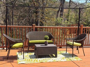 A deck with wicker furniture, including a sofa and two chairs, a small table, and a green plant. - Peaceful Retreat with Massive Private Deck – Free Parking & Easy Highway Access (Vestal)
