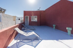 A rooftop terrace with a red wall, a door, and two windows. - GuestReady - Nautilus La Restinga (La Restinga)