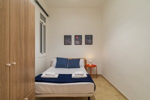 A bedroom with a bed, a nightstand, a lamp, and three wall-mounted pictures. - GuestReady - Eixample Retreat (Barcelona)