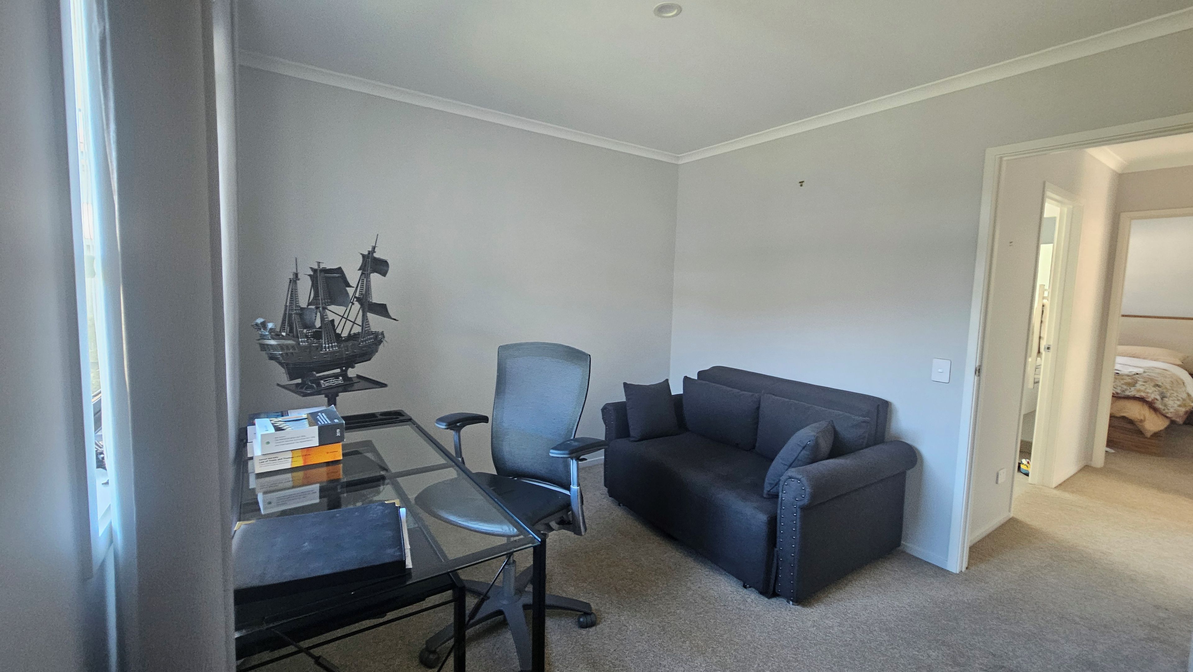 A room with a desk, a chair, a sofa, and a bed.