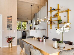Eine moderne Küche mit Holzausstattung, einer Kochinsel und einer Pendelleuchte.