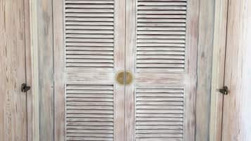 Un juego de puertas dobles con listones horizontales, un pomo de latón y una pequeña placa de latón en el centro.