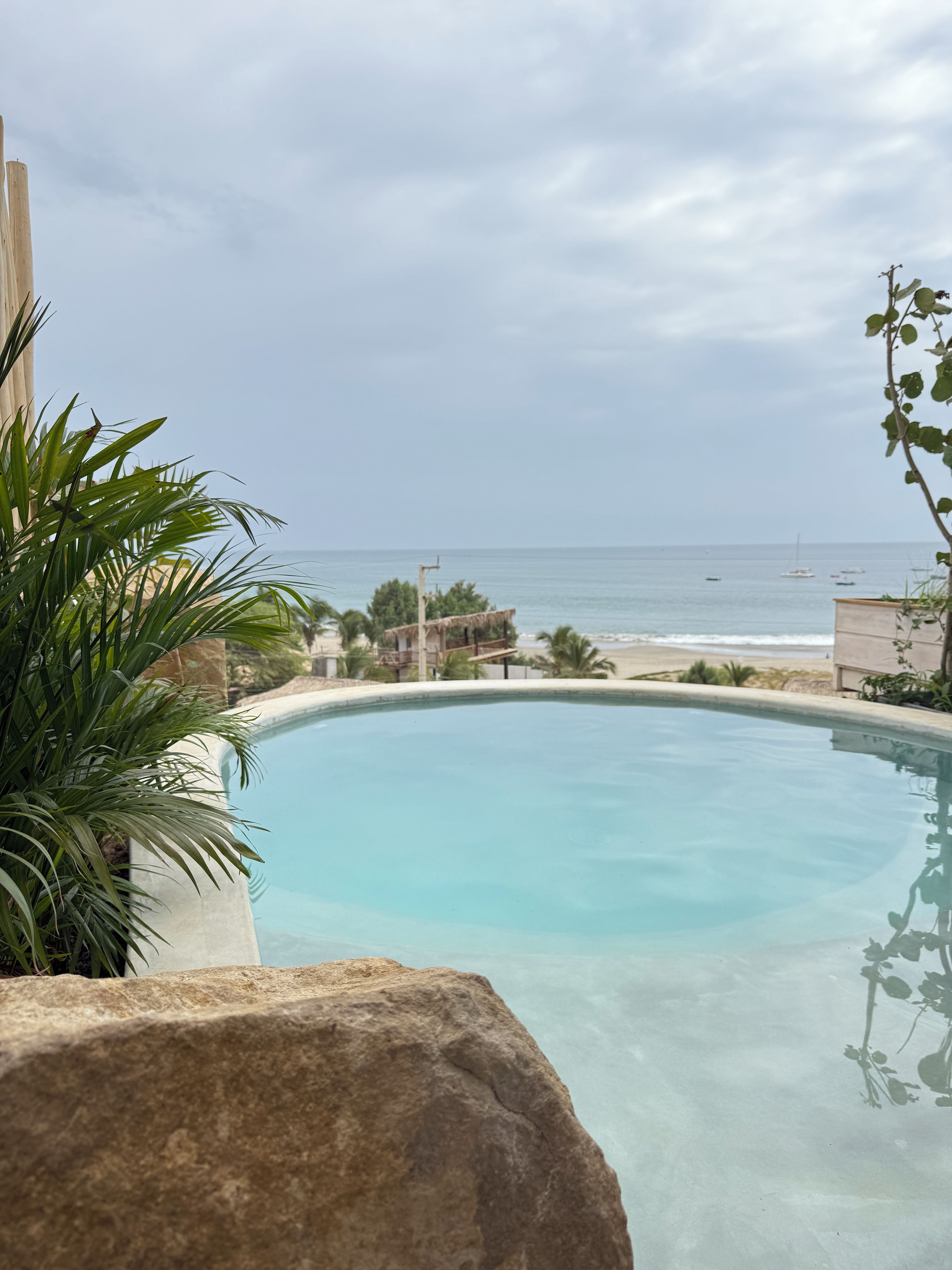 Una piscina con vista al mar y a los barcos.