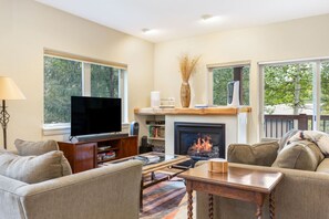 A living room with a fireplace, television, and comfortable seating. - NEW 2BR w/ Hot Tub, Free Shuttle, Parking, WiFi (Vail)