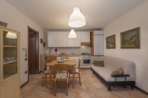 A compact kitchen with a dining area, a sofa, and a small table. - AffittiPontediLegno - Casa Ruby (Ponte di legno)