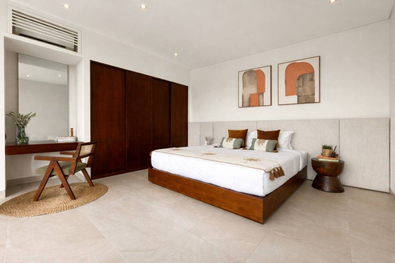 Een moderne slaapkamer met een groot bed, een bureau en een kledingkast.
