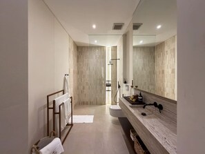 Ein modernes Badezimmer mit großem Spiegel, einem Holzbettchen und einer Duschkabine.