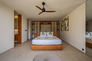 A bedroom with a large bed, a ceiling fan, and artwork on the walls. - NEW 4BR Luxury Family Villa with Pool in Bingin (South Kuta)