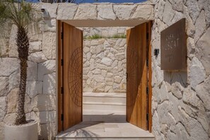A stone wall entrance with two wooden doors, a palm tree, and a sign reading 'CASA MUSCAT'. - NEW 4BR Luxury Family Villa with Pool in Bingin (South Kuta)
