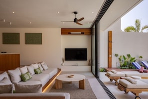 A modern living room with a sofa, coffee table, and a TV mounted on the wall. - NEW 4BR Luxury Family Villa with Pool in Bingin (South Kuta)
