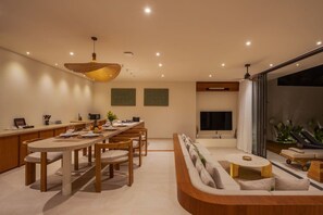 A modern interior with a dining area, a sofa, and a TV. - NEW 4BR Luxury Family Villa with Pool in Bingin (South Kuta)