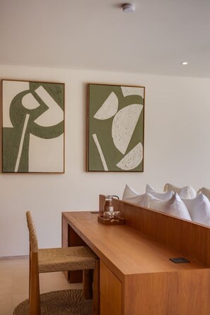 A dining area with a wooden table and chairs, a glass bottle, and two abstract paintings on the wall. - NEW 4BR Luxury Family Villa with Pool in Bingin (South Kuta)