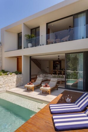 A modern two-story house with a swimming pool, outdoor seating, and a staircase leading to the upper level. - NEW 4BR Luxury Family Villa with Pool in Bingin (South Kuta)