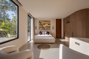 A modern bedroom with a large bed, a view of greenery outside, and a minimalist design. - NEW Stylish 2BR Villa w/ Pool & Rooftop, Bingin (South Kuta)