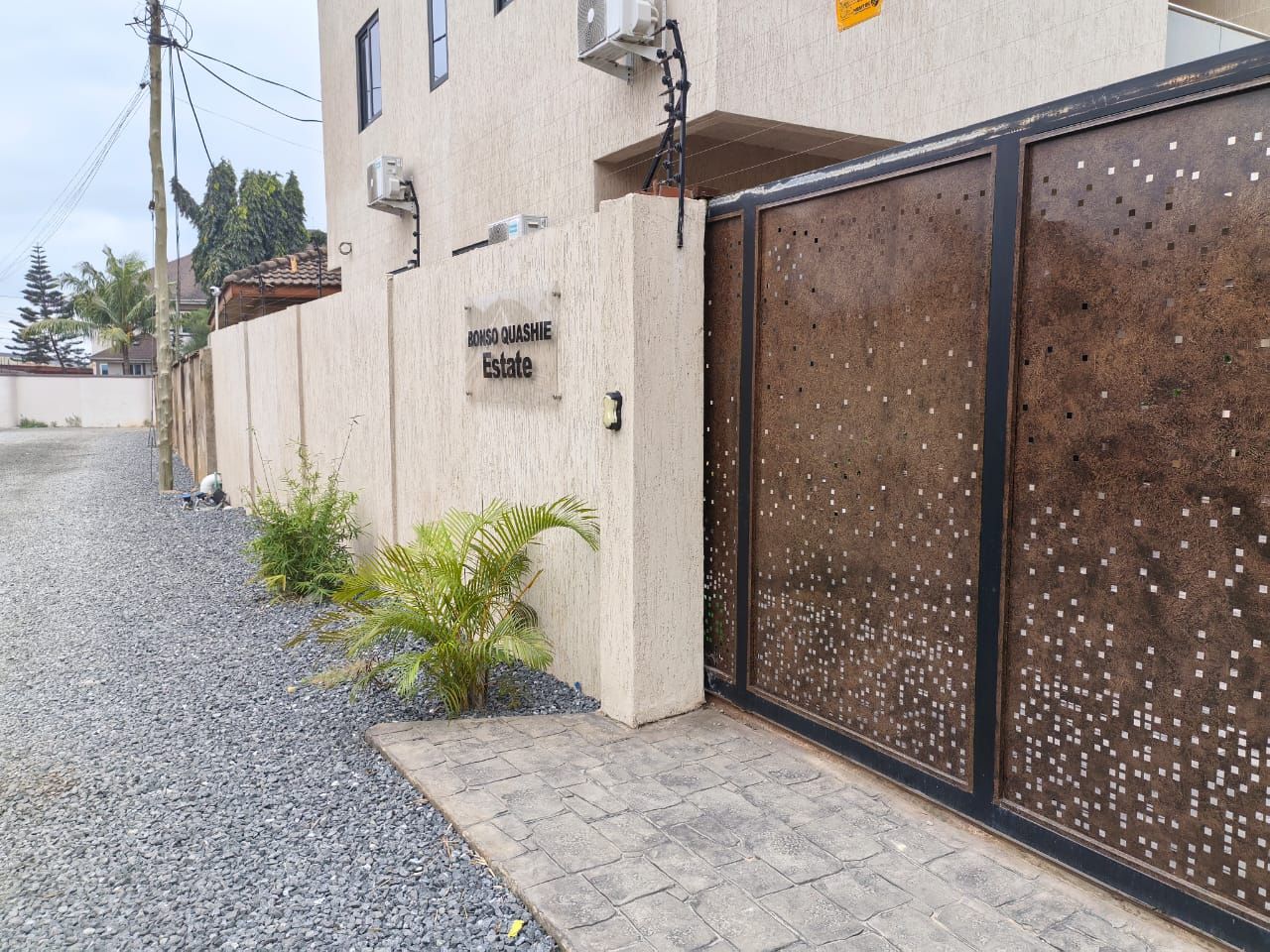 A gated entrance to a building with a sign reading 'BONSO QUASHIE Estate.'