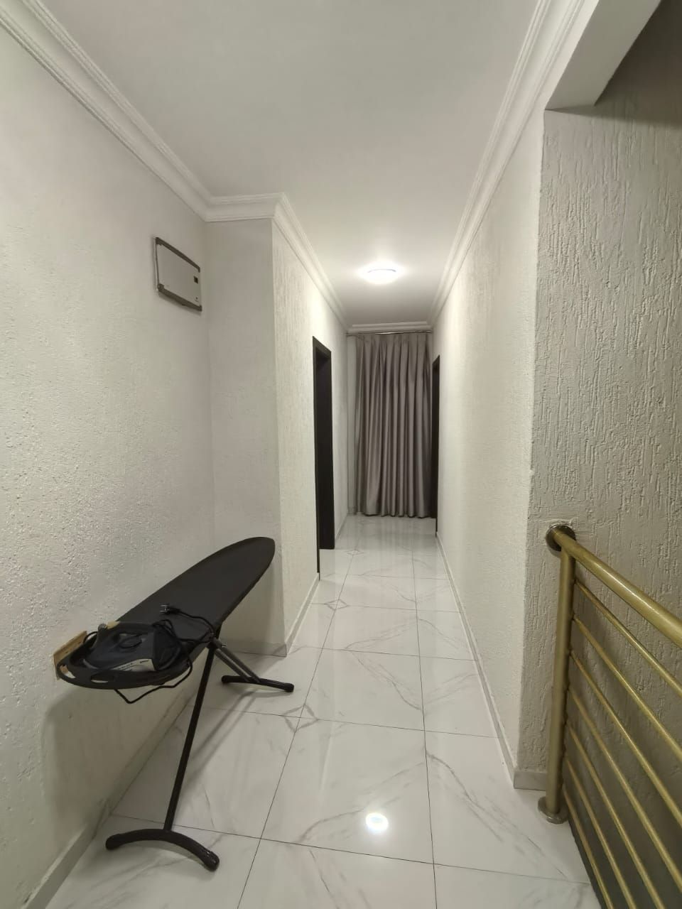 A hallway with a bench, a door, and a curtain.