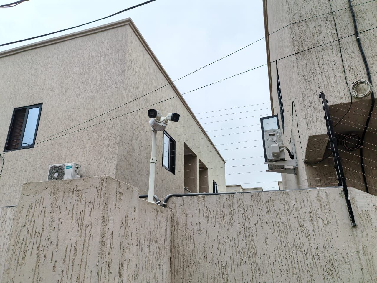 A building with a concrete facade, multiple windows, and visible air conditioning units.