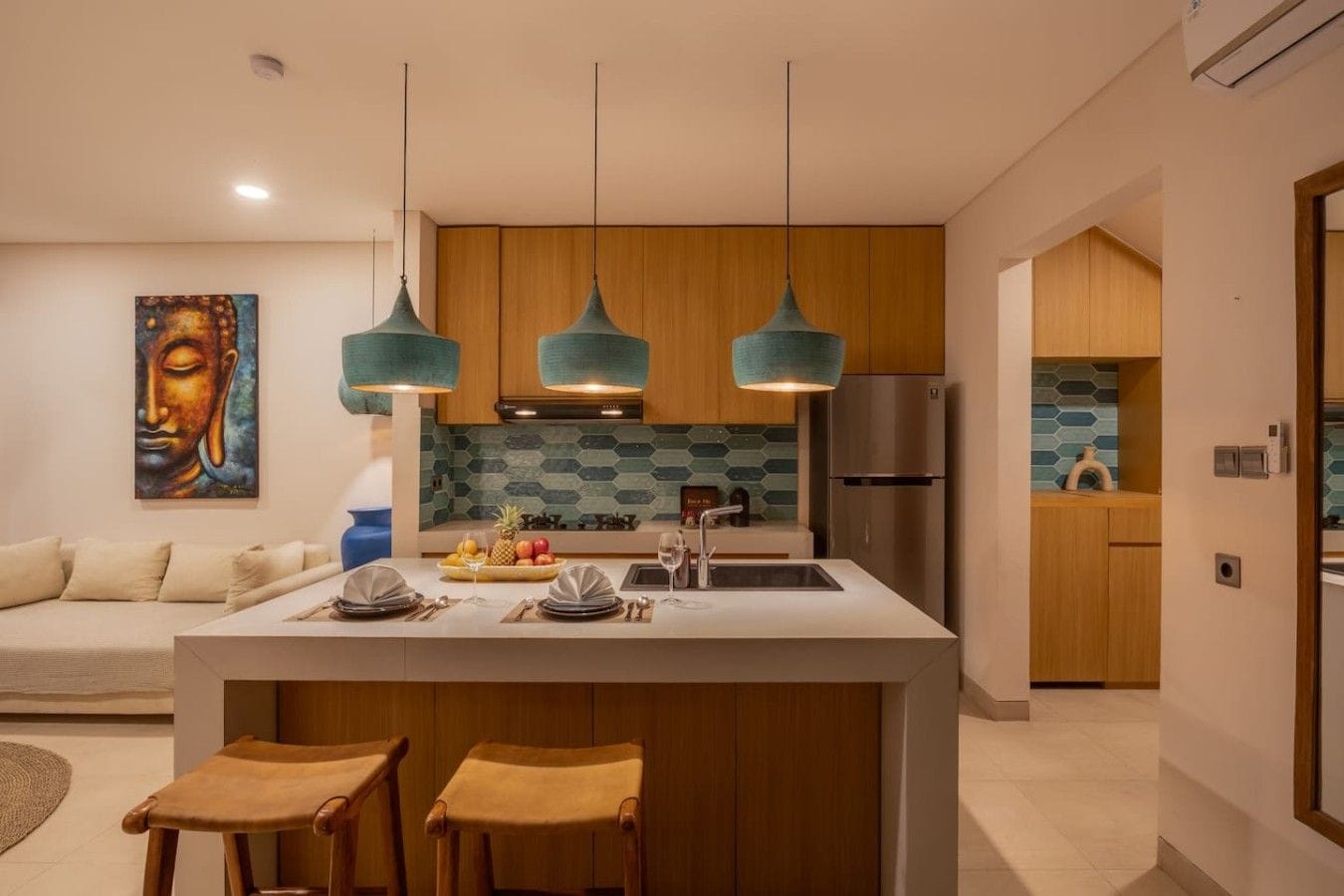 Une cuisine moderne dotée d’un îlot central, de luminaires suspendus et d’un meuble en bois.