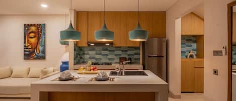 Une cuisine moderne dotée d’un îlot central, de luminaires suspendus et d’un meuble en bois.