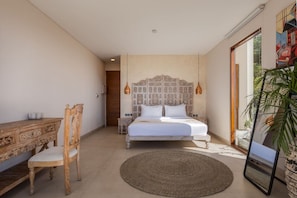 A bedroom with a bed, a wooden chair, a small table, and a large mirror. - 1BR Ocean View Villa w/ Pool – Bingin (South Kuta)