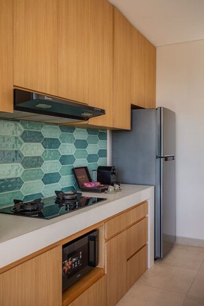 A modern kitchen with wooden cabinets, a stainless steel refrigerator, a gas stove, and a coffee maker. - 1BR Ocean View Villa w/ Pool – Bingin (South Kuta)