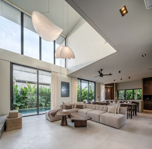 A spacious living area with a large sofa, two coffee tables, and a dining table. - Kulu Villa 4BR Luxury Villa with Rooftop - Uluwatu (South Kuta)