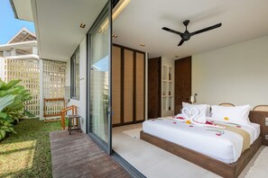 Une chambre moderne avec un grand lit, un ventilateur de plafond et une vue sur l’extérieur.