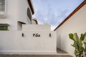A modern building with a white facade, a nameplate reading 'Kaia,' and a small garden area with plants. - Kaia 1BR Villa in the Heart of Bingin, Uluwatu (South Kuta)